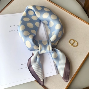 Detail of light blue silk scarf with white polka dots and striped purple accents