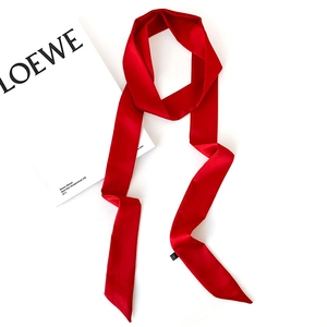 Detail of red satin skinny scarf with diagonal ends and soft silk-like luster texture