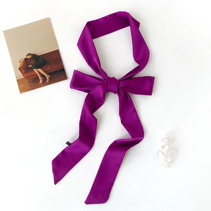 Elegant purple satin skinny scarf tied as a bow on a white textured background