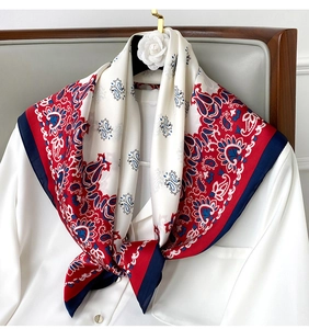 Close-up of red and navy paisley silk scarf styled on a white shirt collar