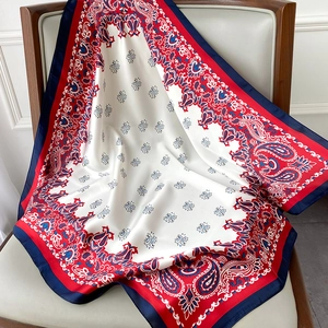 Detail of red and blue paisley silk scarf draped over a chair showing satin texture