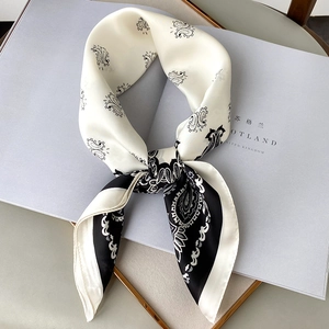Elegant black and white paisley silk scarf with satin finish on white magazine background