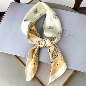 Detail of silk scarf with paisley patterns and yellow border on a stylish display