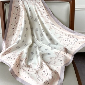 Detailed view of paisley silk-like satin scarf with cream and pink floral textures