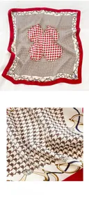Close-up of silk scarf fabric showing houndstooth pattern with nautical chain details