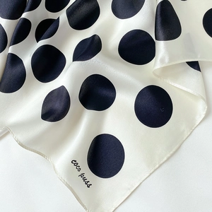 Close-up of premium silk polka dot scarf showing smooth fabric texture and fine hem details