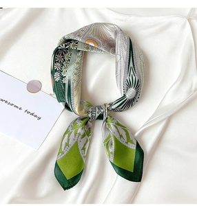 Detailed view of dark green silk square scarf with daisy print and elegant knot