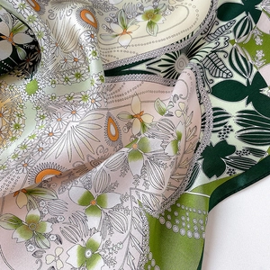 Macro shot of floral silk square scarf showing detailed print and satin fabric texture