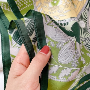 Close-up of printed silk scarf showing intricate floral patterns and hand-rolled edges