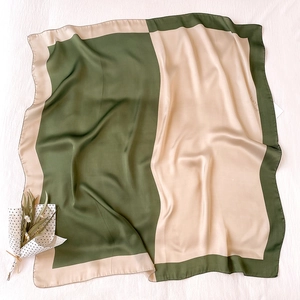 Dettaglio di un elegante foulard in raso bicolore con design a blocchi di colore