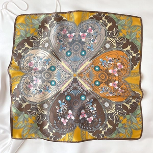 Detail of square silk scarf with yellow clover pattern and floral center print