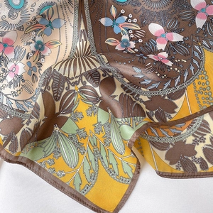 Macro shot of printed silk square scarf with vintage floral patterns and smooth texture