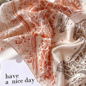 Gros plan d'un foulard carré en soie avec imprimé carte urbaine et texture satinée