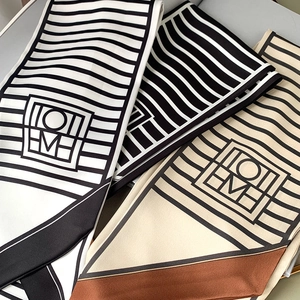 Close-up of geometric black and white striped silk scarves with premium textures