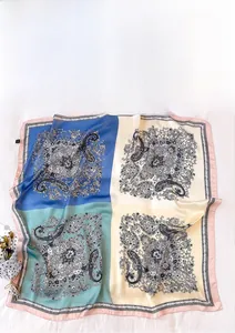 Macro detail of cashew patchwork silk scarf with paisley pattern and pink rolled edges