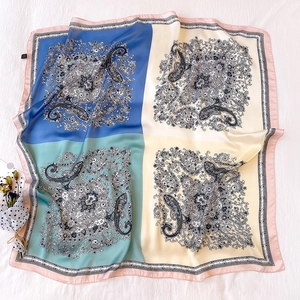 Close-up of paisley pattern and floral motifs on a colorful silk-feel square scarf