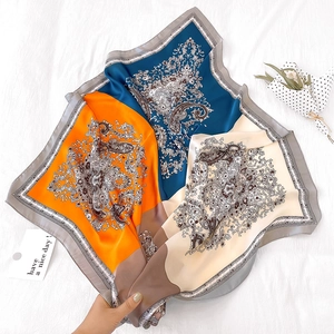 Macro detail of tricolor paisley silk scarf showing soft fabric texture and patterns