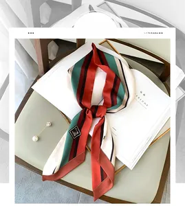 Macro detail of striped vintage silk scarf in green and red on a white magazine
