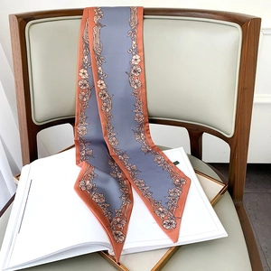 Détail d'un foulard étroit à fleurs drapé sur une chaise en bois, lumière douce