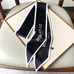 Detalle de un pañuelo de seda twilly en blanco y negro con texto ROMNTIC PARIS en bandeja