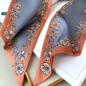 Détail d'un foulard en soie à imprimé floral montrant des motifs de fleurs délicats