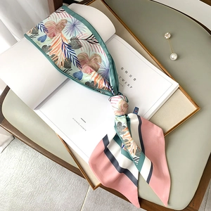 Détail d'un foulard en soie à feuilles de palmier tropical et glands sur un magazine