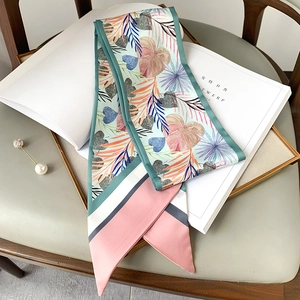 Détail d'un foulard twilly imprimé avec motif de feuilles tropicales sur magazine