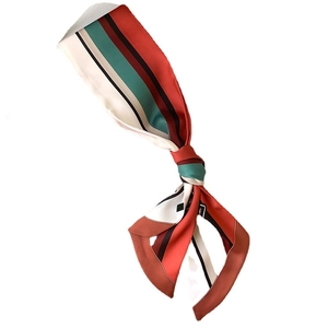 Narrow twilly silk scarf with geometric stripes in red, green, and black for hair or bags