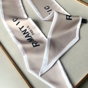 Detalle de pañuelo de satén champán con estampado Romantic Paris y etiqueta de lavado