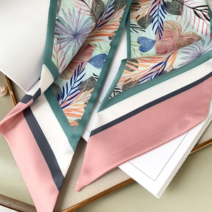 Détail d'un foulard en soie à motif de palmier tropical sur un plateau de présentation