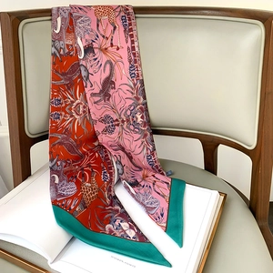 Détail d'un foulard en soie imprimé animaux de la jungle drapé sur des livres et une chaise