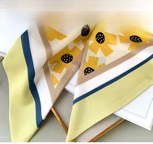 Detail of floral silk scarf featuring yellow flower prints and striped hem stitching