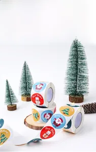 Detail of round Christmas snowman stickers on roll with festive holiday props and pine cones