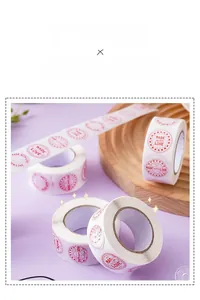 Macro shot of round Valentine stickers with Made with Love text for gift packaging