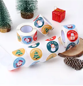 Close-up of circular Merry Christmas stickers with Santa and snowman on a gift roll