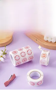 Roll of round white gift stickers with red hearts and Made With Love text detail