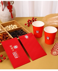 Close-up of red New Year envelopes and paper cups with cartoon dragon seal stickers