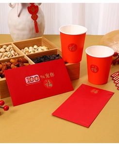 Festive Lunar New Year gift set with red cups, envelopes, and a wooden tray of dried fruits