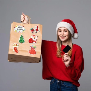 Close-up of holographic Christmas stickers showing Santa and tree on gift bags