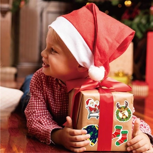 Child holding gift box decorated with holographic Christmas Santa and reindeer stickers