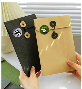 Close-up of vintage kraft and black envelopes with panda reward stickers and string closures