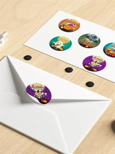 Close-up of Halloween stickers with pumpkin and ghost motifs on a white envelope