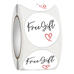 Roll of white circular Free Gift stickers with black script and red heart for packaging
