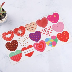 Detail of 15 heart-shaped Valentine stickers on marble surface with gold foil accents