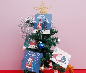Détail de cartes de Noël avec motifs de Père Noël sur un sapin de fête décoré