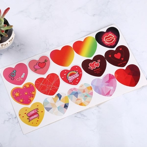 Rainbow heart stickers for Valentine gift wrapping with gold foil accents on marble