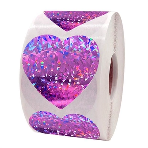 Macro shot of purple laser heart stickers roll with sparkling diamond texture on white back