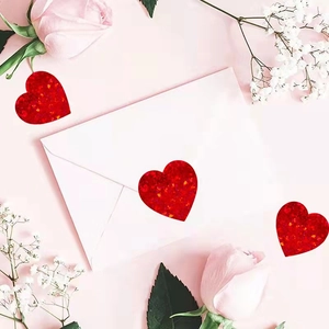 Sparkling red heart glitter stickers on envelope with elegant pink rose background