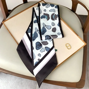 Detail of blue-grey stone pattern narrow scarf with a decorative golden metal ring buckle