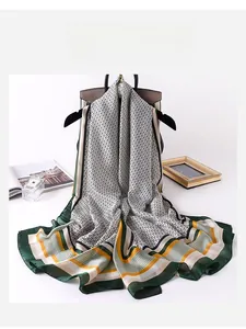 Detailed view of a lightweight silk scarf with geometric patterns draped over a stylish bag